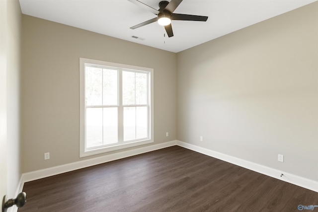 empty room with dark wood finished floors, visible vents, ceiling fan, and baseboards