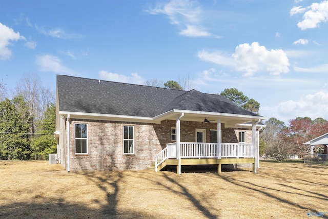 view of front of property with a deck, brick siding, roof with shingles, and ceiling fan