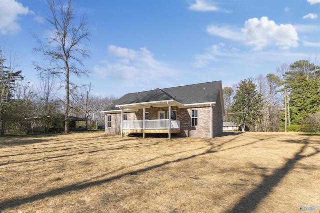 exterior space with a ceiling fan and brick siding