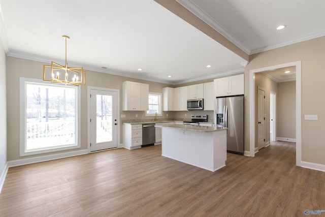 kitchen featuring a sink, stainless steel appliances, a chandelier, and white cabinetry