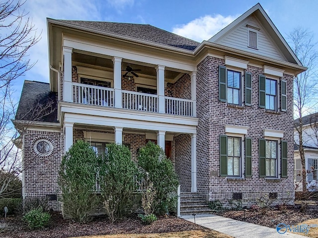 view of front of property with a ceiling fan, brick siding, a balcony, and roof with shingles