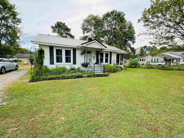 ranch-style home featuring covered porch and a front lawn