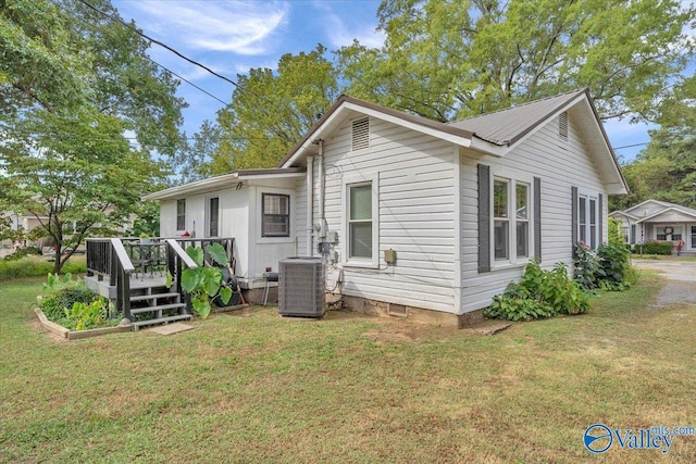 back of house with cooling unit, a lawn, and a wooden deck