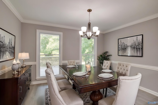 dining area with light wood finished floors, plenty of natural light, a chandelier, and ornamental molding