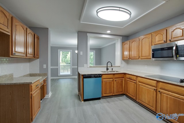 kitchen featuring light wood finished floors, baseboards, appliances with stainless steel finishes, crown molding, and a sink