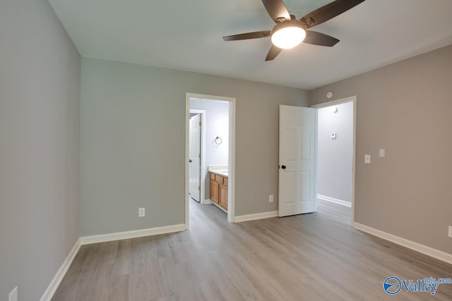 unfurnished bedroom featuring light wood finished floors, ensuite bath, baseboards, and ceiling fan