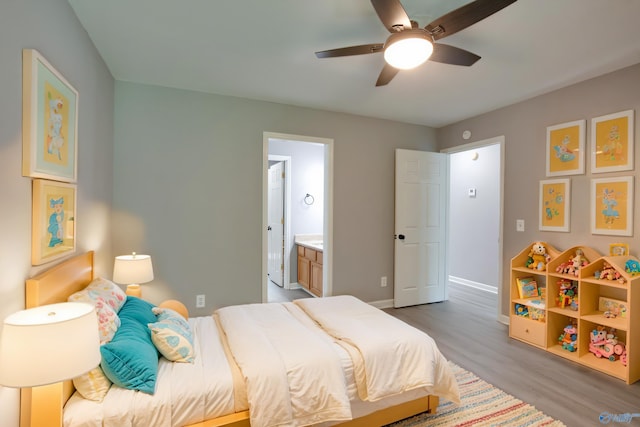bedroom featuring baseboards, connected bathroom, light wood finished floors, and ceiling fan