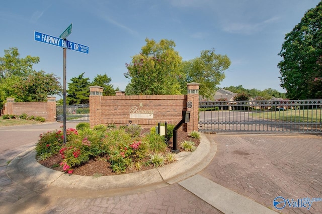 community sign featuring fence and a gate