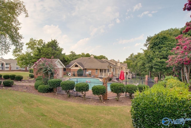 community pool featuring a yard, fence, and a residential view