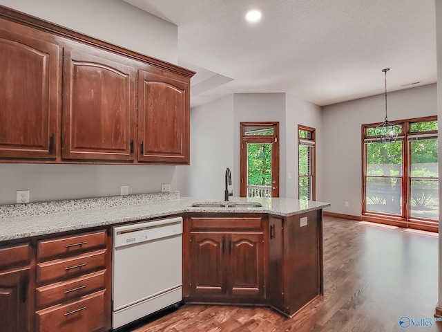 kitchen with dark wood-type flooring, sink, white dishwasher, kitchen peninsula, and light stone countertops