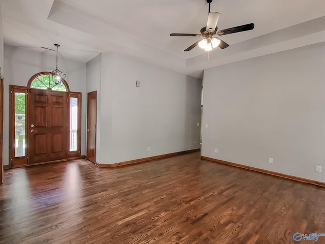 entrance foyer with a raised ceiling, ceiling fan, and dark hardwood / wood-style flooring