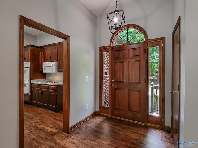 foyer entrance with dark hardwood / wood-style floors and a notable chandelier