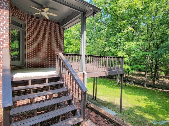 wooden deck featuring ceiling fan and a yard