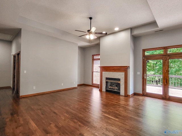 unfurnished living room featuring dark hardwood / wood-style floors, a textured ceiling, a fireplace, and ceiling fan