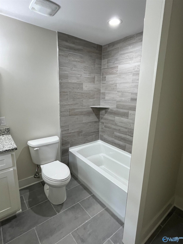 full bathroom featuring tile patterned flooring, tiled shower / bath, vanity, and toilet