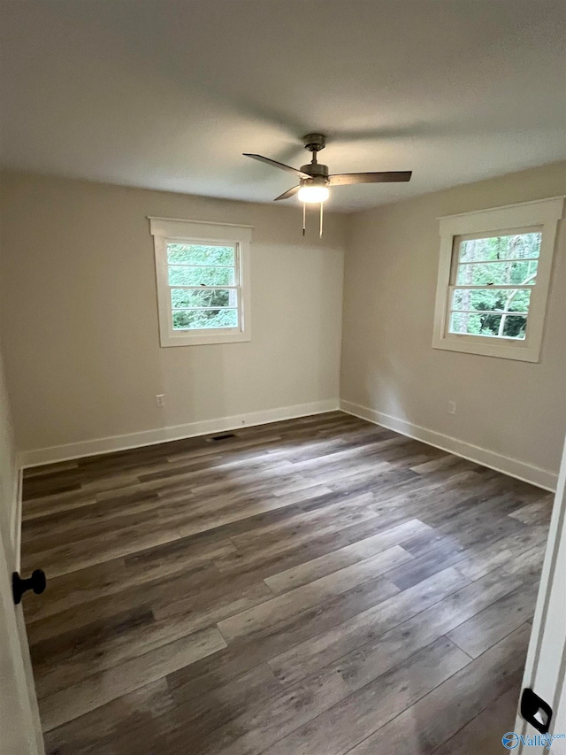 unfurnished room featuring ceiling fan, dark hardwood / wood-style floors, and a healthy amount of sunlight