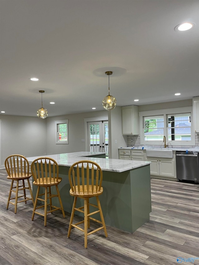 kitchen featuring pendant lighting, a healthy amount of sunlight, and stainless steel dishwasher