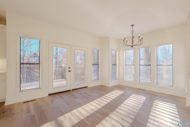 unfurnished sunroom featuring french doors, visible vents, and an inviting chandelier