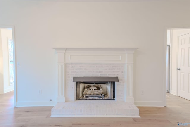 interior details featuring a fireplace, wood finished floors, and baseboards