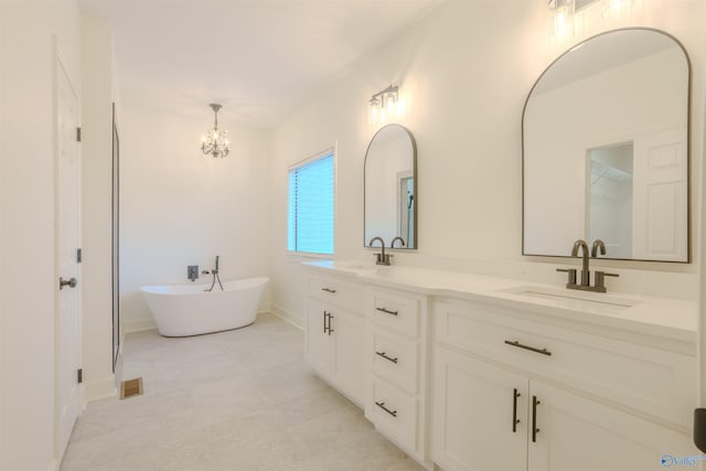 bathroom featuring a chandelier, a soaking tub, a sink, and double vanity