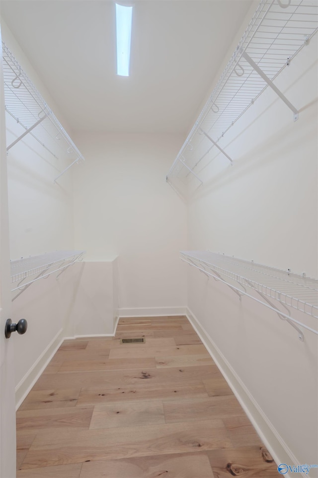 spacious closet featuring light wood-style flooring