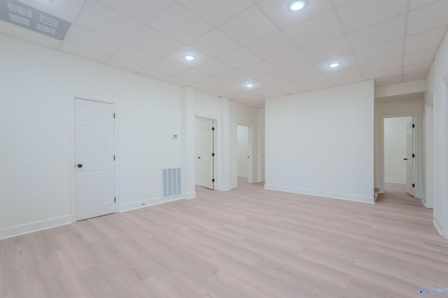 spare room featuring baseboards, visible vents, and light wood finished floors