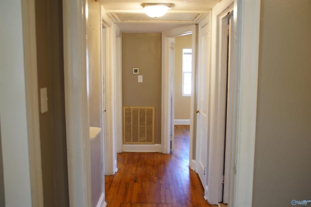 hallway featuring visible vents and wood finished floors