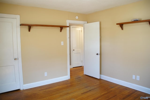 unfurnished bedroom with baseboards and wood finished floors
