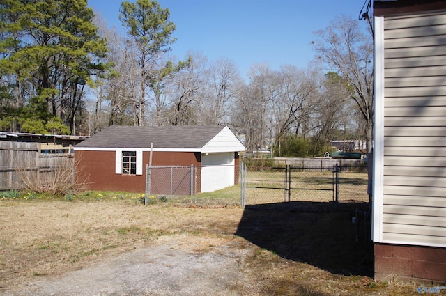 view of yard featuring an outbuilding, a gate, and fence