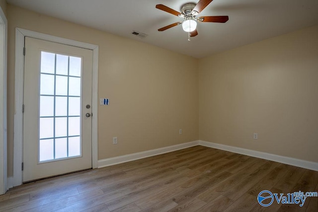 doorway to outside with a ceiling fan, light wood-type flooring, visible vents, and baseboards