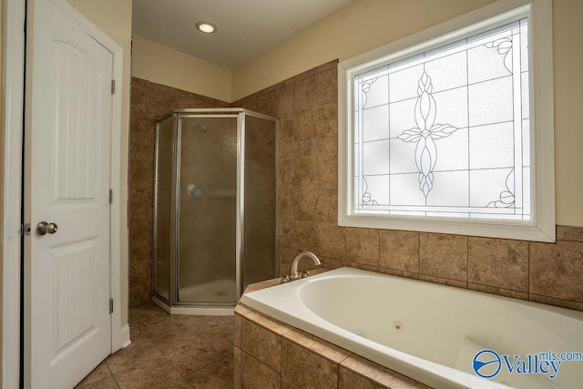 full bathroom featuring a whirlpool tub, a stall shower, and tile patterned flooring