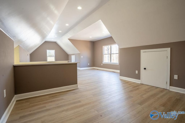 additional living space featuring lofted ceiling, recessed lighting, light wood-style flooring, and baseboards