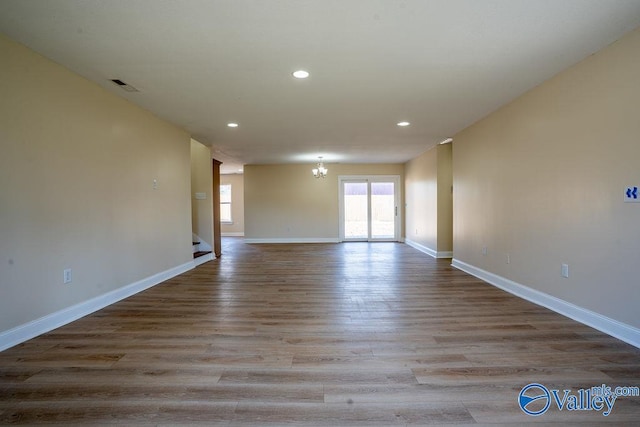 spare room with baseboards, visible vents, wood finished floors, and recessed lighting