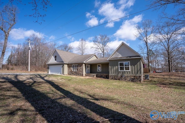 view of front of home with dirt driveway, an attached garage, board and batten siding, a front yard, and stone siding