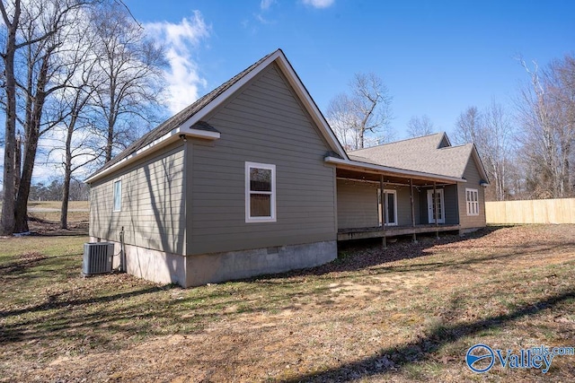 view of side of home with a yard, cooling unit, crawl space, and fence