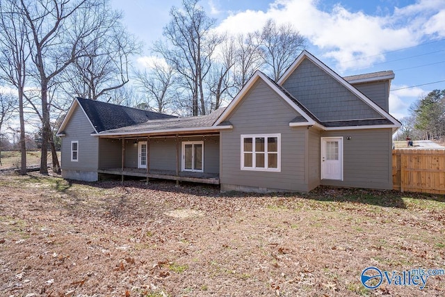back of house with crawl space and fence