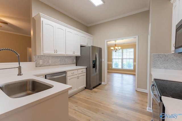 kitchen with stainless steel appliances, a sink, white cabinetry, and crown molding