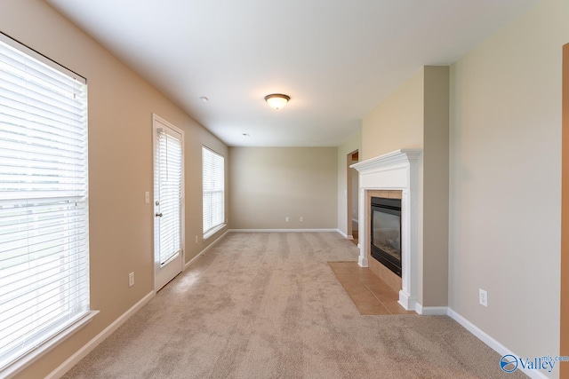 unfurnished living room with a tiled fireplace and light carpet