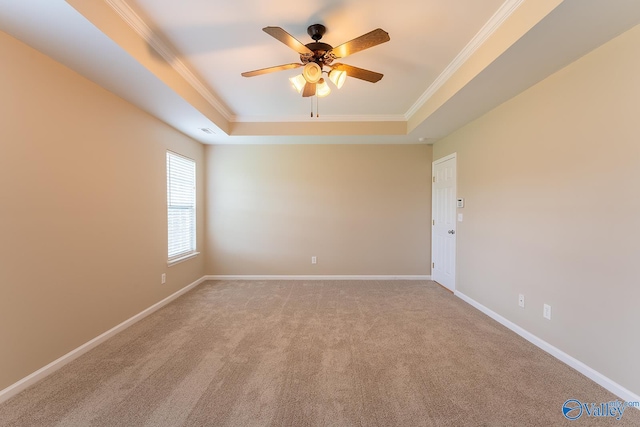 empty room with crown molding, a raised ceiling, and ceiling fan