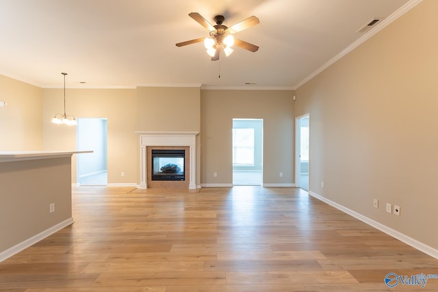 unfurnished living room featuring ceiling fan with notable chandelier, a multi sided fireplace, light hardwood / wood-style floors, and ornamental molding