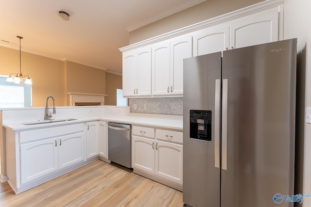 kitchen featuring light wood-type flooring, decorative light fixtures, appliances with stainless steel finishes, and white cabinets