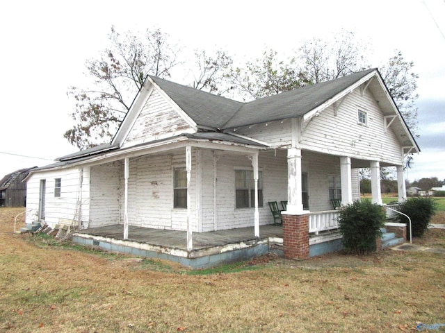 view of property exterior featuring covered porch and a yard