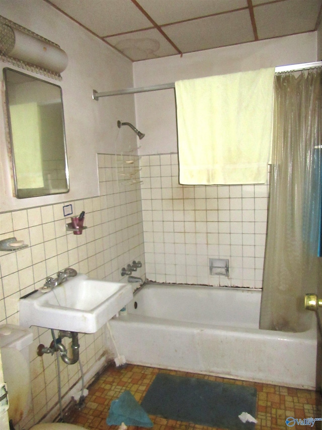 bathroom featuring tile patterned flooring, tile walls, sink, and shower / bath combination with curtain