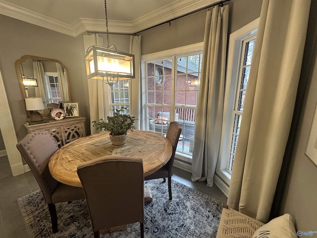 tiled dining room featuring a notable chandelier and ornamental molding