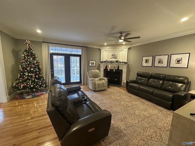 living room featuring a fireplace, ceiling fan, light hardwood / wood-style flooring, and ornamental molding