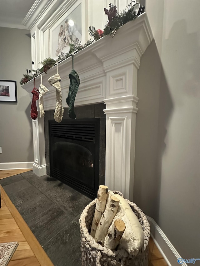 details featuring a tiled fireplace and ornamental molding