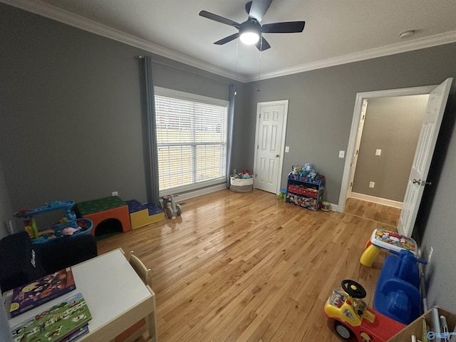 recreation room with hardwood / wood-style flooring, ceiling fan, and ornamental molding