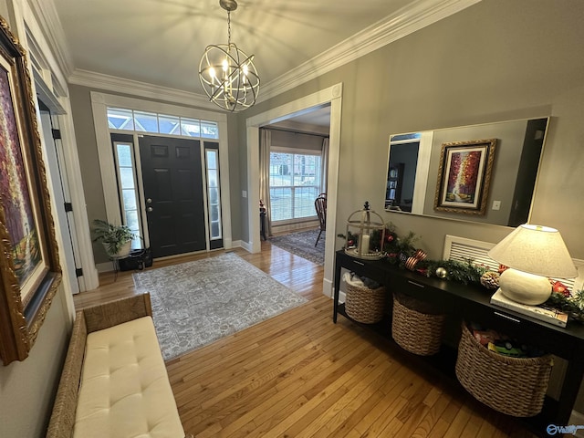 entrance foyer featuring a chandelier, light hardwood / wood-style floors, and crown molding