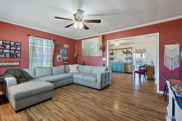 living room featuring crown molding, hardwood / wood-style flooring, sink, and ceiling fan