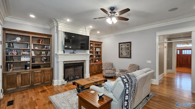 25 Cypress Grove Ln, Huntsville, AL 35824 - living area featuring a ceiling fan, a glass covered fireplace, light wood-style flooring, crown molding, and baseboards